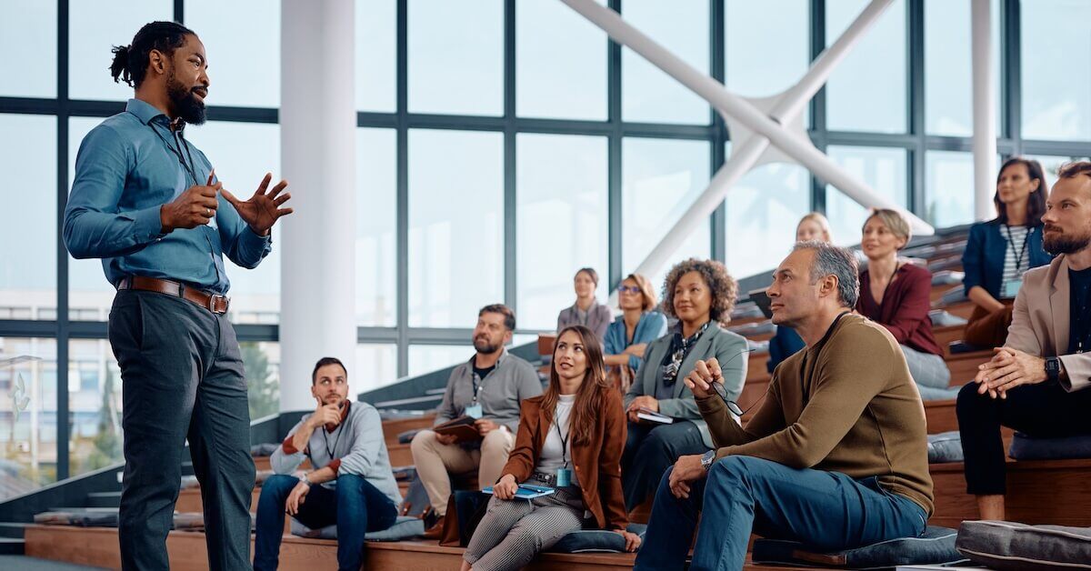 A sales training presenter greets his audience.