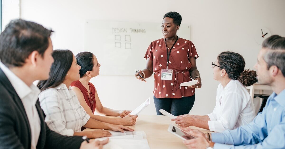 A sales training instructor leads a cohort in an exercise.